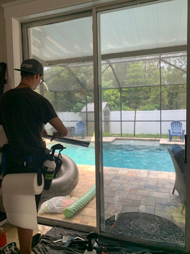 Residential window film installation in progress on poolside sliding glass doors by Tint by the Bay