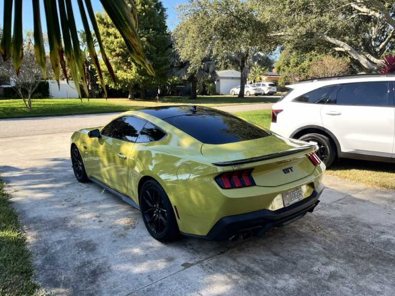 Rear side view of yellow Ford Mustang after automotive window tint installation by Tint by the Bay