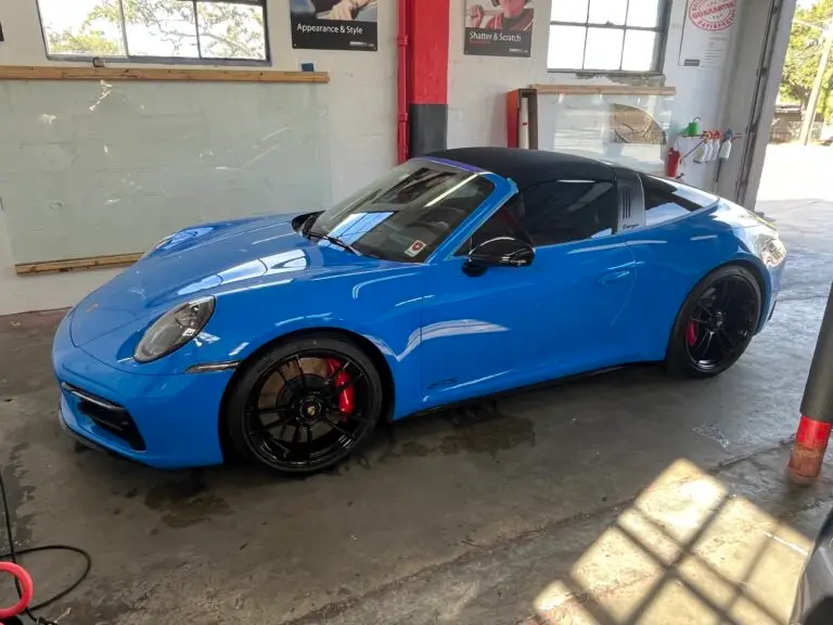 Blue Porsche sports car with professional automotive window tint installed by Tint by the Bay